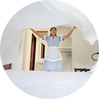 caregiver putting fresh sheets on a bed