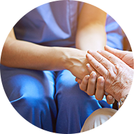 caregiver holding a resident's hand while in conversation